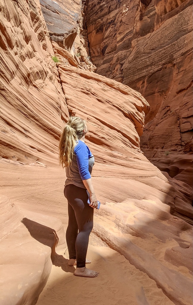 Standing barefoot between red rock canyon walls