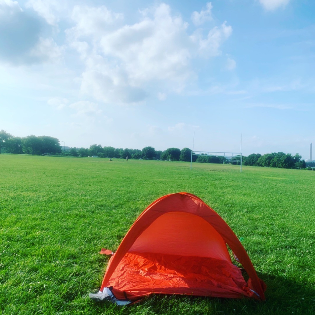 An orange tent on an open field